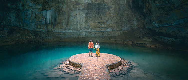 Couple exploring underground natural pool in Yucatán Peninsula of Mexico.
